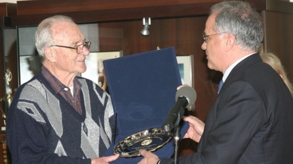 Погледът на възрастния човек с побеляла коса и очила не